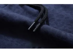Detailed close-up of dark blue knit fabric with textured drawstring and matte tip