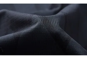 Macro shot of black ripstop quick-dry fabric showing breathable grid texture and pattern