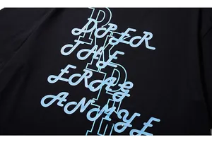 Gros plan sur l'impression de lettres bleu clair sur un t-shirt noir oversize en coton
