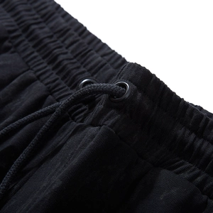 Men's loose fit black sports shorts with drawstring waistband and metal eyelets