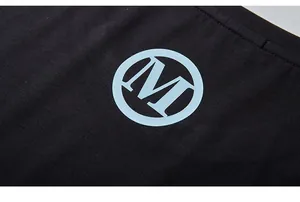 Detail of black cotton fabric showing clear knit texture and light blue M logo print