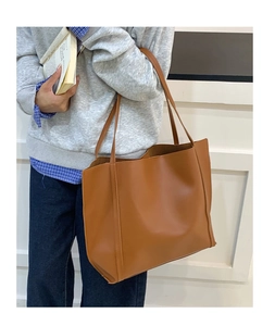 Borsa tote marrone capiente e minimalista abbinata a felpa grigia e jeans casual