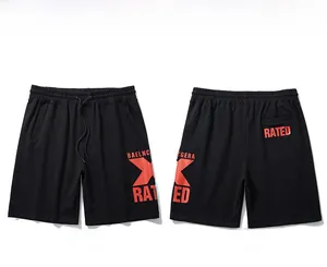 Detail of drawstring waist and bold red X print on black loose sports shorts