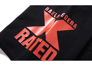 Close-up of black cotton shorts featuring vibrant orange graphic print and lettered design