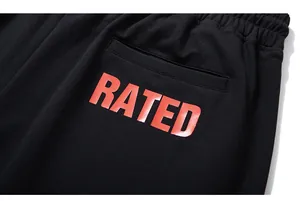 Close-up of black cotton sweatpants with bold red RATED text print on the back pocket
