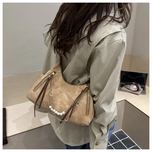 Détail du sac cabas en daim kaki avec bandoulière en perles blanches et chaîne en métal