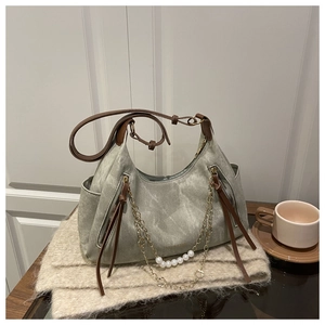 Vue détaillée du sac hobo en toile gris-vert avec chaîne dorée et perle