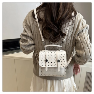 Mini white polka dot backpack with Tidal Dryness print shown on a model's back