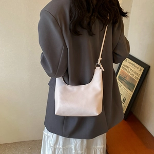 Sac hobo minimaliste en cuir crème avec boucles argentées et bandoulière nouée