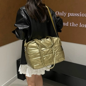 Sac fourre-tout matelassé doré métallisé avec bandoulière porté par un mannequin chic