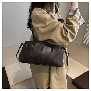 Detail of dark brown matte PU leather tote bag with vertical stitching and drawstring