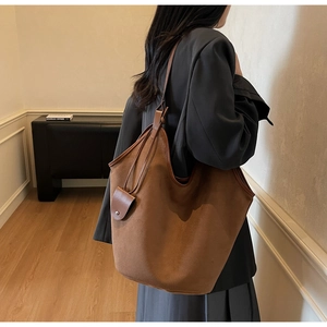 Close-up of caramel brown oversized tote bag in matte suede with matching shoulder strap