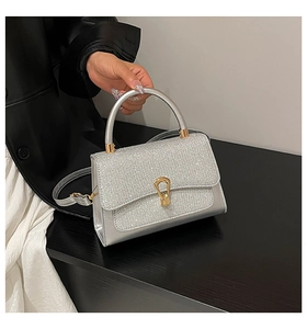 Détail du sac à main à paillettes argentées avec boucle dorée et bandoulière