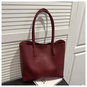 Detail of burgundy leather tote bag showing matte finish and premium vertical stitching