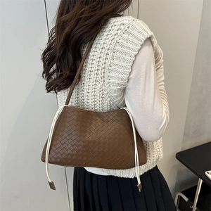 Borsa a tracolla intrecciata marrone con lacci bianchi da donna su una modella