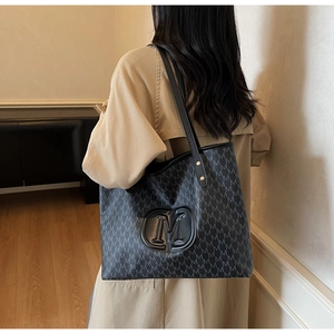 Detail of grey tote bag with all-over M monogram pattern and 3D relief logo on surface