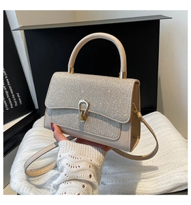 Vue détaillée du sac beige à strass scintillants avec des finitions en métal doré