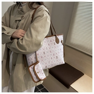 Détail de l'ensemble cabas blanc avec motifs d'ours et poignées en cuir marron