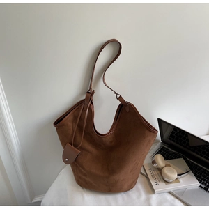 Close-up of tobacco brown suede tote bag with matching side pouch and long shoulder strap