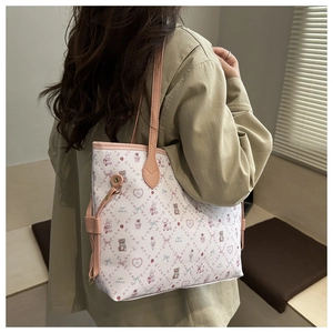Détail d'un grand sac cabas avec motifs de dessins animés et finitions en cuir rose sur modèle