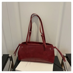 Detail shot of the red vintage tote bag featuring side drawstrings and metallic eyelets