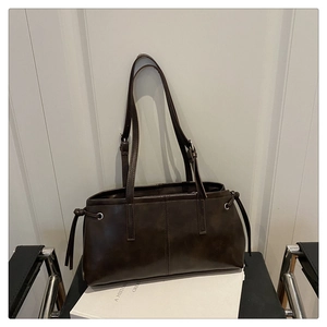Detail of vintage coffee brown tote bag with matte texture and side drawstring accents