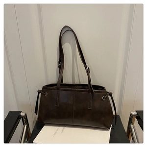 Detail of dark brown vintage faux leather tote bag with drawstring knots and fine stitching