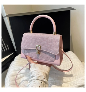 Détail d'un sac à main rose avec strass brillants et boucle fer à cheval dorée élégante