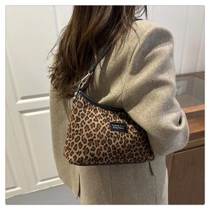Close-up of leopard print shoulder bag with black strap and silver hardware accents