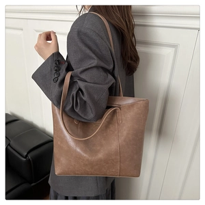 Gros plan d'un sac cabas marron vintage montrant la finition texturée et les bretelles