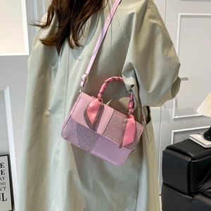 Pink minimalist square bag with sequin stitching and scarf-wrapped handle on a model