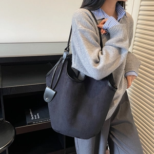 Minimalist black matte tote bag for women with large capacity shown on model's shoulder