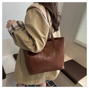 Grand sac cabas marron en similicuir avec texture fine porté par un mannequin