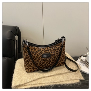 Detail of leopard print suede shoulder bag with black leather trim and silver hardware
