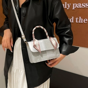 Silver square crossbody bag with sequin detail and red patterned silk scarf handle