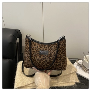 Dettaglio borsa tote leopardata con finiture in pelle nera e fibbie metalliche argento