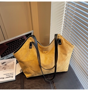 Detailed view of yellow quilted suede tote bag with gold lock and black straps
