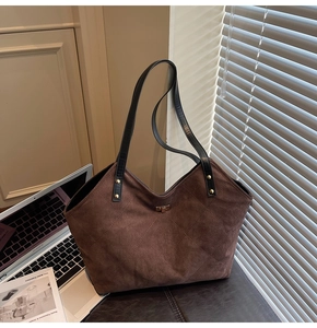 Close-up of brown quilted tote bag with matte finish and elegant metal lock detail
