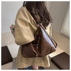 Detail view of large dark brown PU leather tote bag with adjustable metal buckle strap