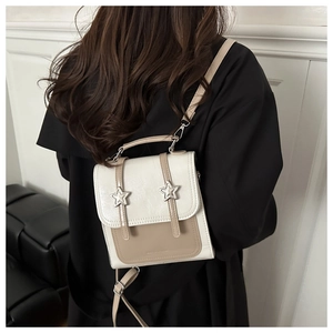 Détail du mini sac à dos avec breloques étoiles, sangles réglables et design bicolore
