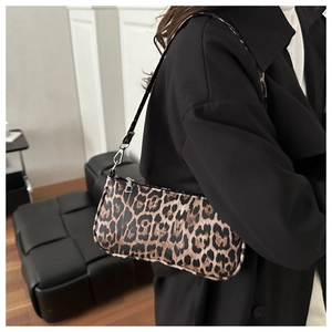 Detailed view of leopard print underarm bag worn with a black wool coat for styling