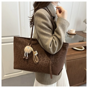Détail du grand sac cabas léopard marron avec son pendentif peluche et pampille