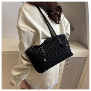 Dettaglio di una borsa tote nera con motivo leopardo e finiture in metallo dorato