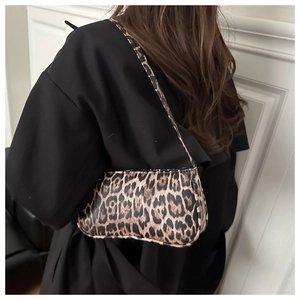 Detail showing vintage leopard print shoulder bag worn by model on black top