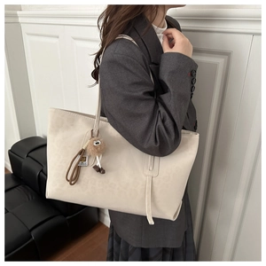 Détail du grand sac cabas léopard beige avec cordon tressé et porte-clé monstre en peluche
