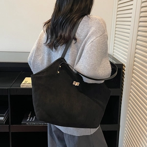 Fashionable black matte suede tote bag with gold swivel lock and slim shoulder strap