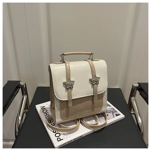 Détail d'un sac à dos bicolore minimaliste avec boucles étoiles et poignée supérieure