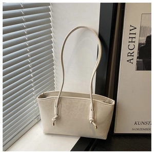 Dettaglio della borsa tote in pelle PU bianco crema con logo impresso e spalline lunghe