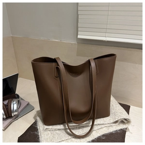 Detailed view of the dark brown tote bag texture with fine logo printing and strap
