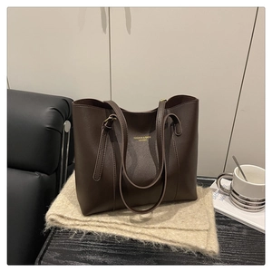 Detail of dark brown tote bag with gold FASHION & BAGS LEATHER embossing and leather texture
